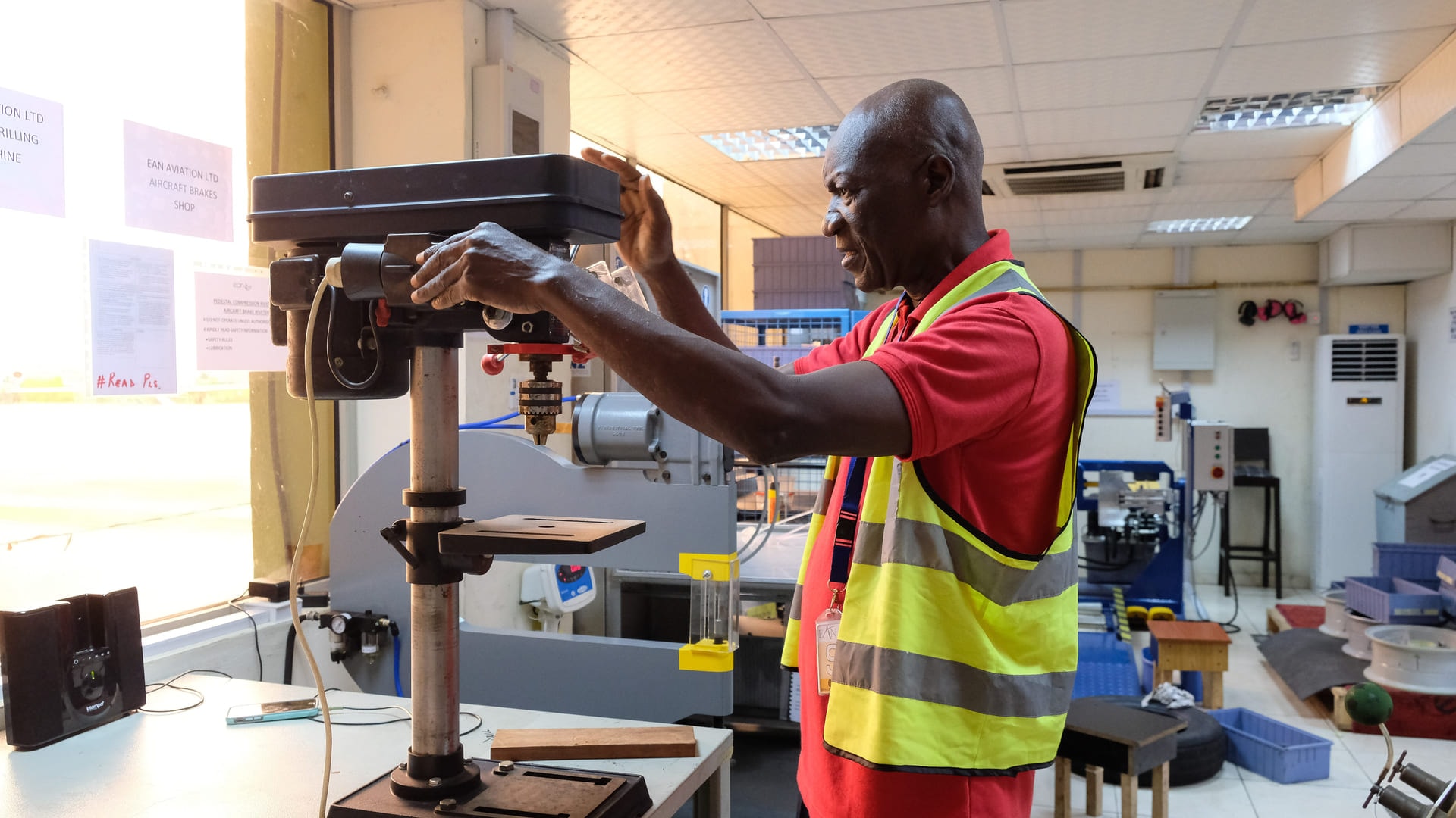 A technician operating a pedestal drilling machine in EAN Aviation’s aircraft brakes shop.