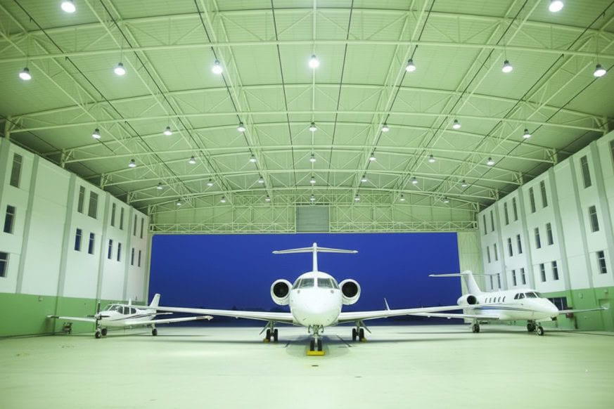 The interior of EAN’s hangar, with a business jet centred between a light aircraft and a second jet under the roof trusses.