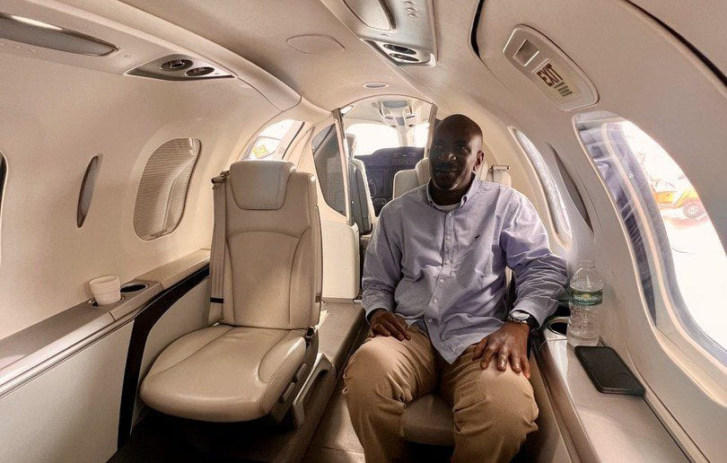 Tayo Aiyetan seated in the cabin of a light business jet.